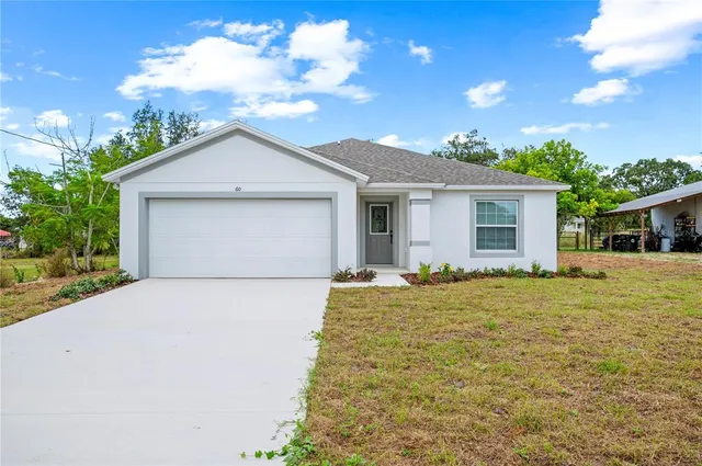 a front view of house with yard and trees in the background