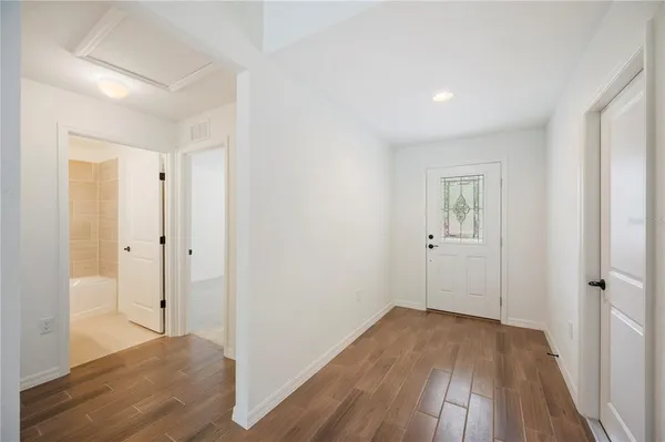 a view of a room with wooden floor and a bathroom