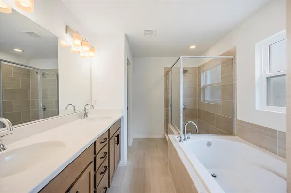 a bathroom with a tub sink and mirror