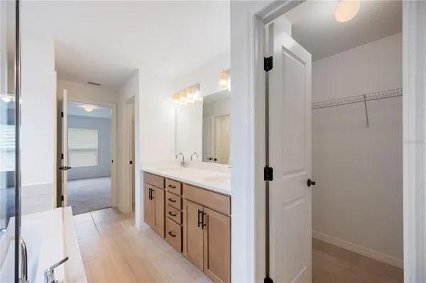 a spacious bathroom with a double vanity sink a mirror and a shower
