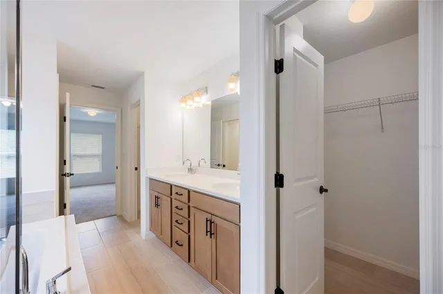a spacious bathroom with a double vanity sink a mirror and a shower