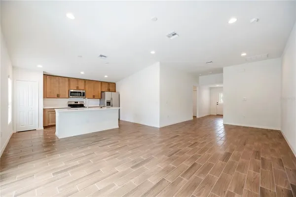 a view of kitchen with kitchen island stainless steel appliances refrigerator and stove top oven