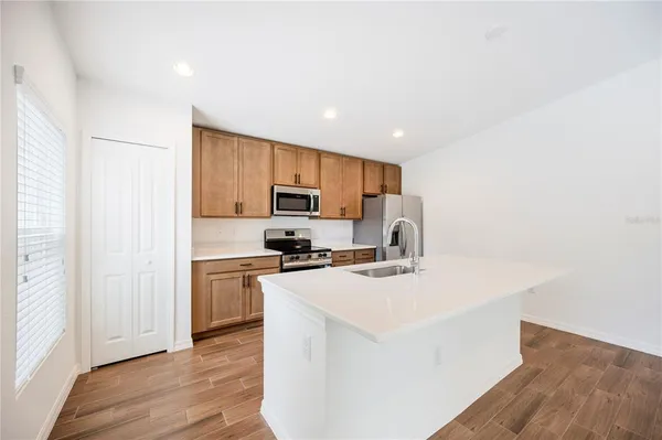 a kitchen with stainless steel appliances a stove top oven a sink a refrigerator a window