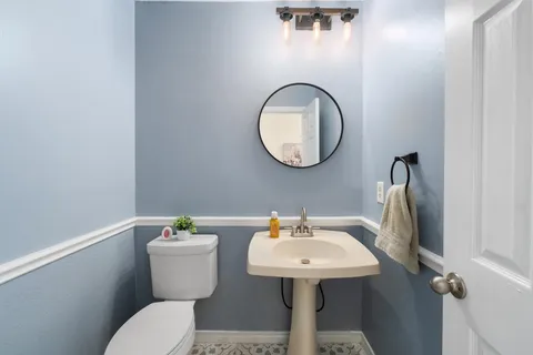 a spacious bedroom with a bed and a flat tv screen on dresser