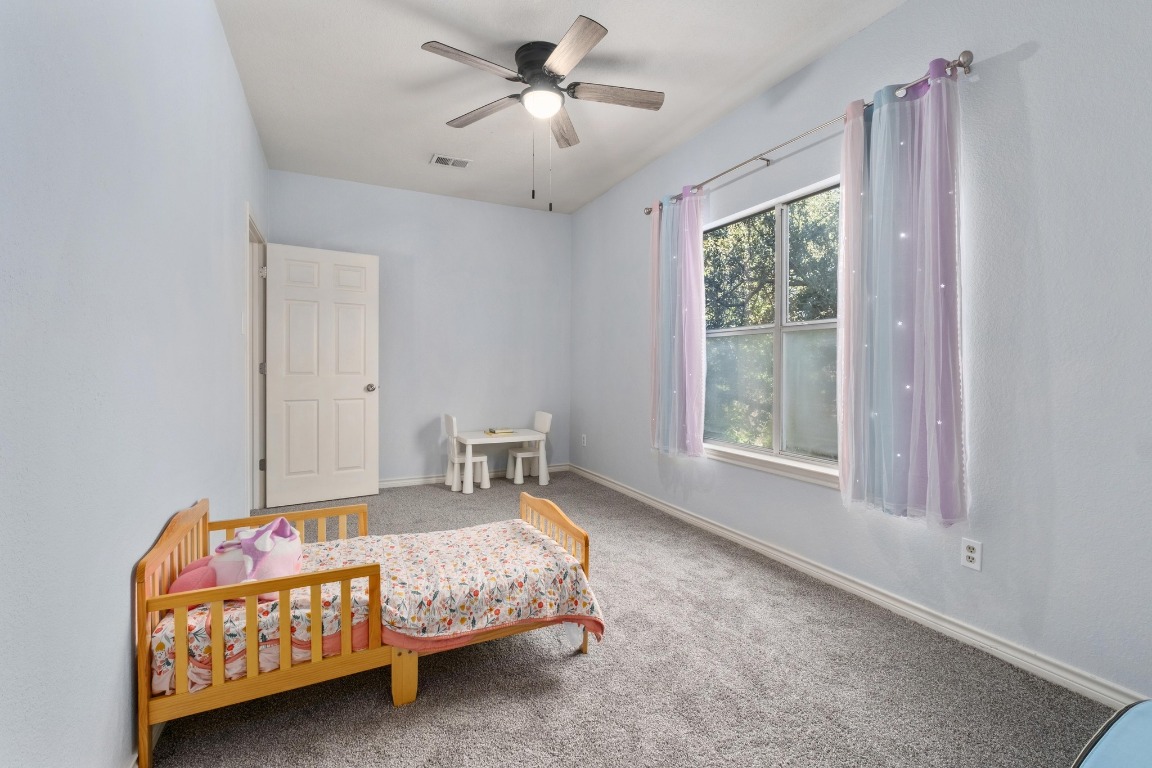 3808 Latimer Drive Austin, TX 78732 - Photo 25 of 31 a bedroom with a bed a chandelier and a window