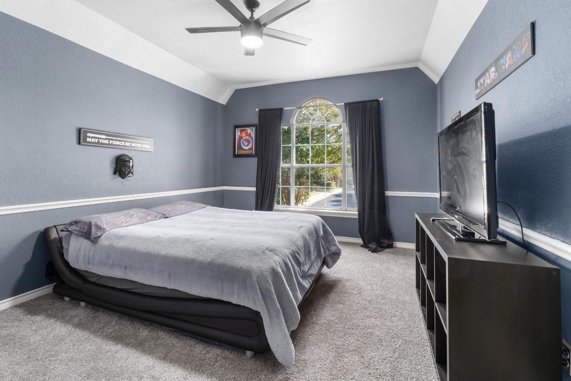 3808 Latimer Drive Austin, TX 78732 - Photo 27 of 31 a bedroom with a bed and a flat tv screen on dresser