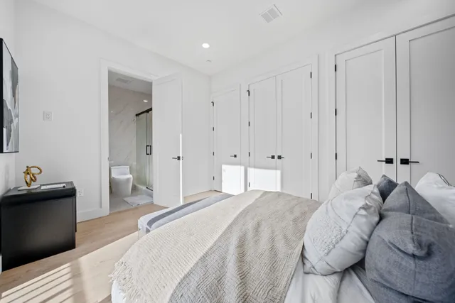 a spacious bedroom with a bed and a refrigerator