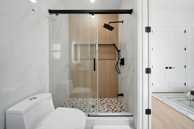 a view of an empty room with wooden floor and closet