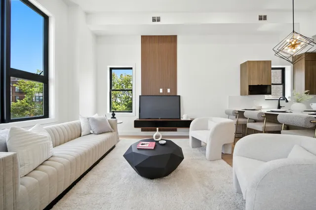 a large white kitchen with a large window and stainless steel appliances