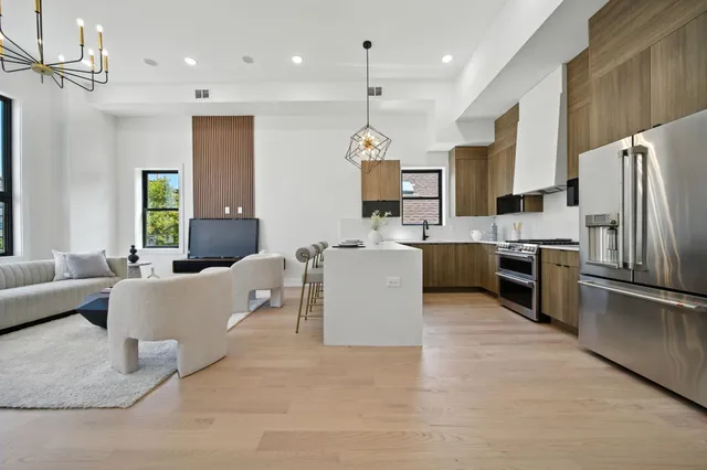 a kitchen with a refrigerator a stove top oven a sink dishwasher and white cabinets with wooden floor