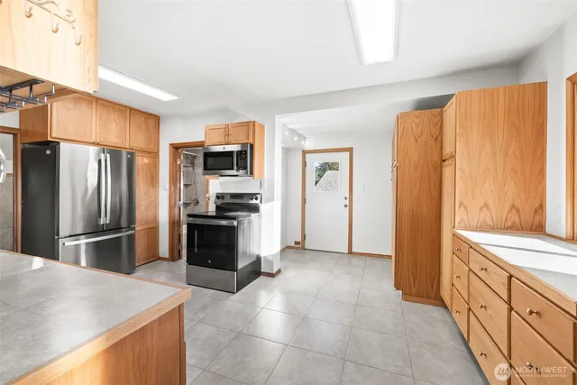 a kitchen with granite countertop a refrigerator and a stove top oven