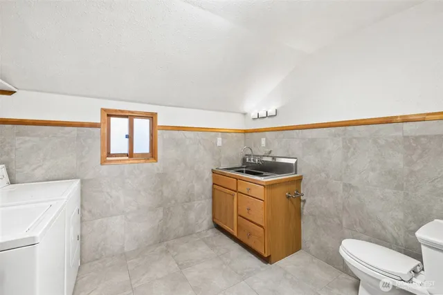 a bathroom with a granite countertop sink a toilet and mirror
