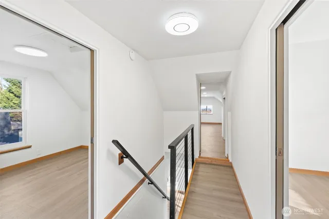 a view of a hallway with wooden floor and staircase