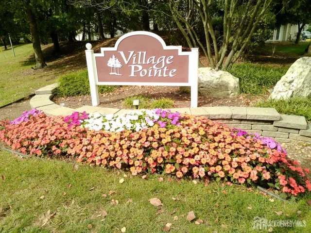 a sign that is sitting in front of flowers