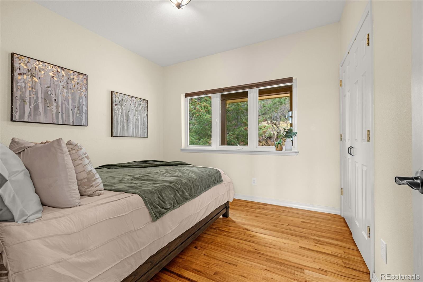 25 Leaming Road Colorado Springs, CO 80906 - Photo 22 of 48 a bedroom with a bed and wooden floor