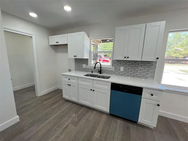 a view of a kitchen with cabinets and wooden floor