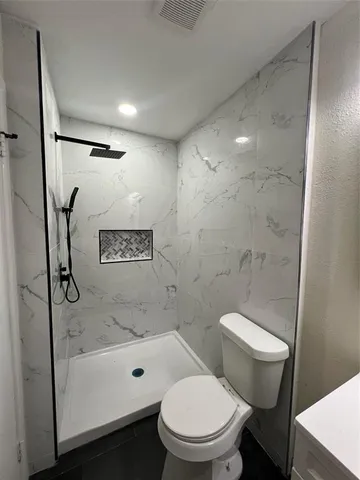 a bathroom with a toilet a sink and shower