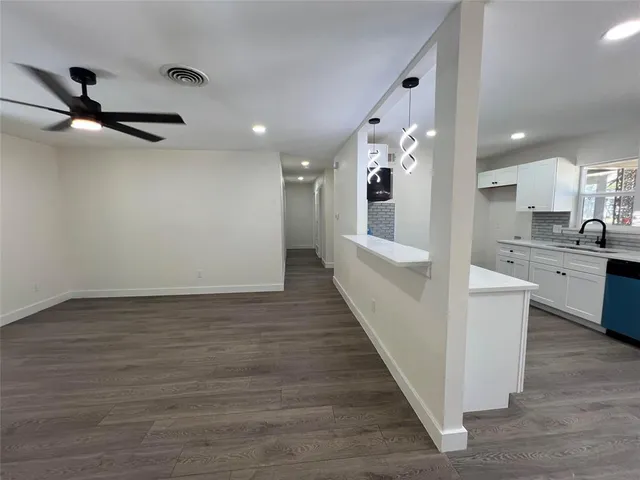 a view of room with wooden floor and ceiling fan