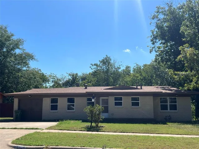 a large white kitchen with kitchen island a stove a sink dishwasher and a refrigerator with wooden floor