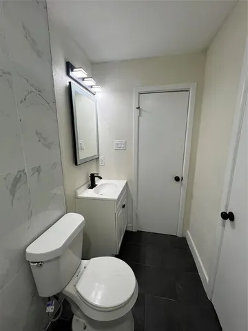 a white toilet sitting next to a bathroom sink