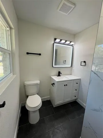 a white toilet sitting next to a bathroom sink