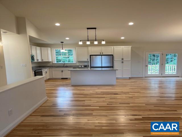 791 Westwood Road Stanardsville, VA 22973 - Photo 20 of 24 a view of a kitchen with kitchen island granite countertop wooden floor stainless steel appliances and a window