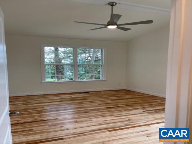 791 Westwood Road Stanardsville, VA 22973 - Photo 7 of 24 an empty room with wooden floor chandelier fan and windows