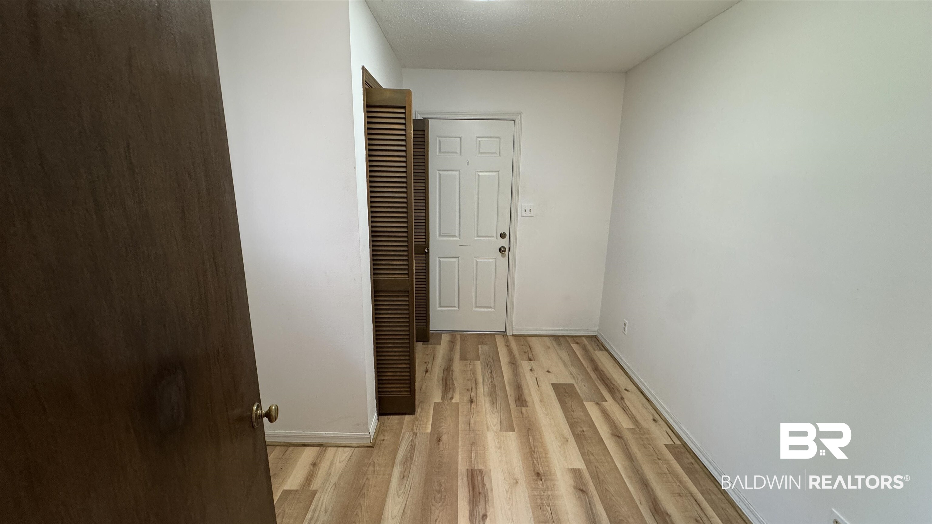 33370 Highway 98 Lillian, AL 36549 - Photo 37 of 58 Freshly painted white walls complementing wood-finish flooring