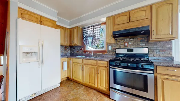 a kitchen with stainless steel appliances granite countertop cabinets and a stove top oven