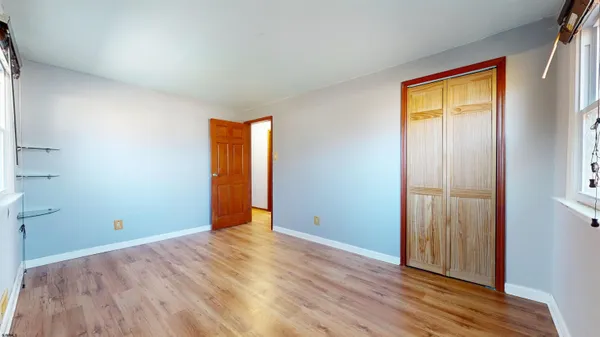 an empty room with wooden floor and closet