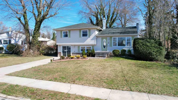 a front view of a house with yard porch and tree