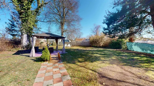 a view of a backyard with table and chairs under an umbrella