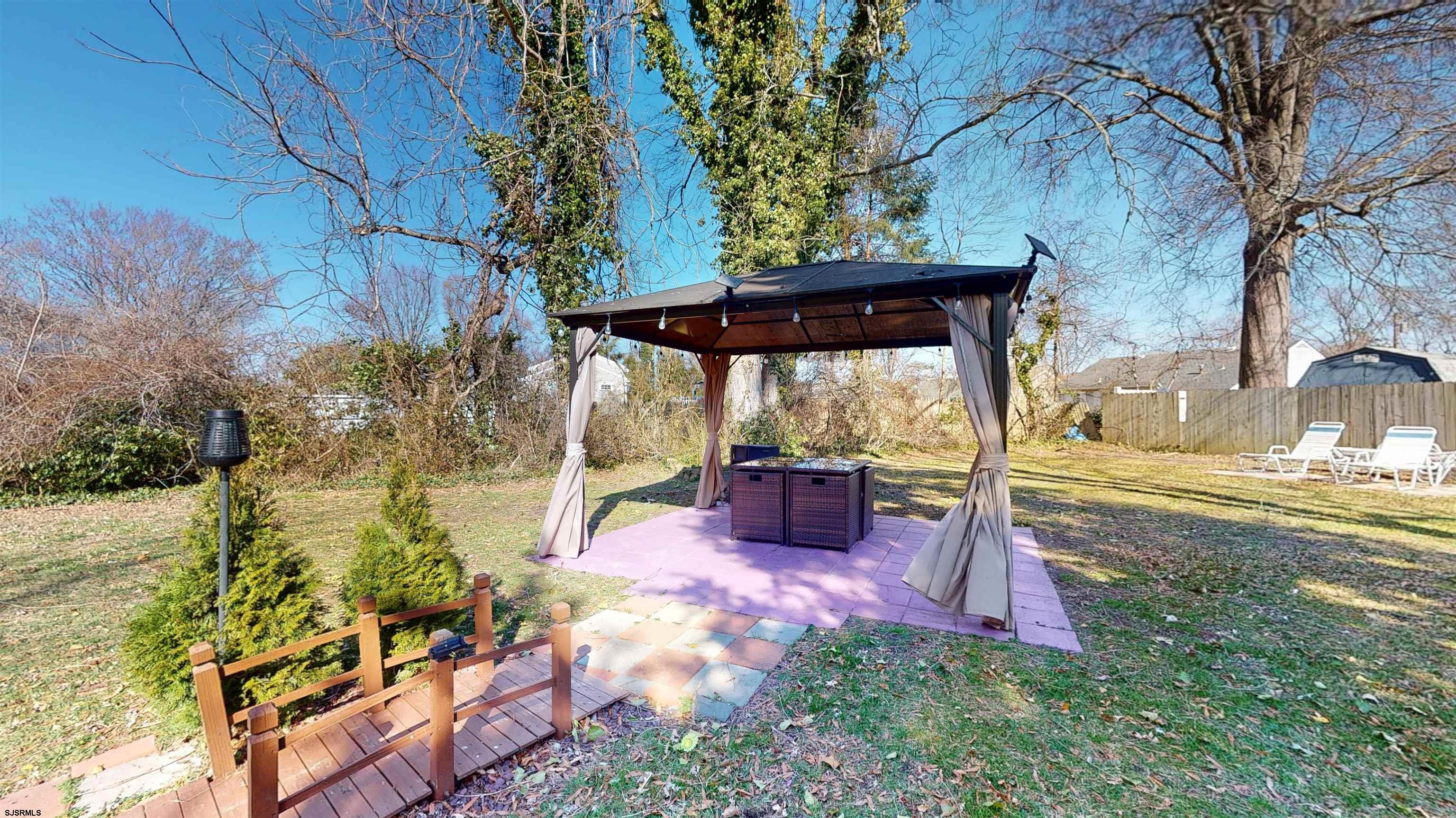 123 Devon Road Somers Point, NJ 08244 - Photo 36 of 41 a view of a backyard with table and chairs under an umbrella