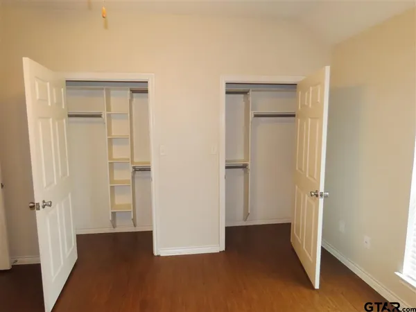 an empty room with closet and wooden floor