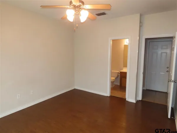 an empty room and a bathroom with a sink