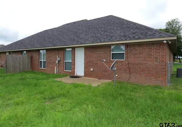 a backyard of a house with barbeque oven and plants