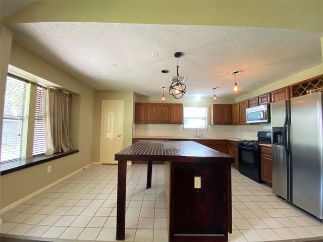a kitchen with stainless steel appliances granite countertop a sink counter space and a window