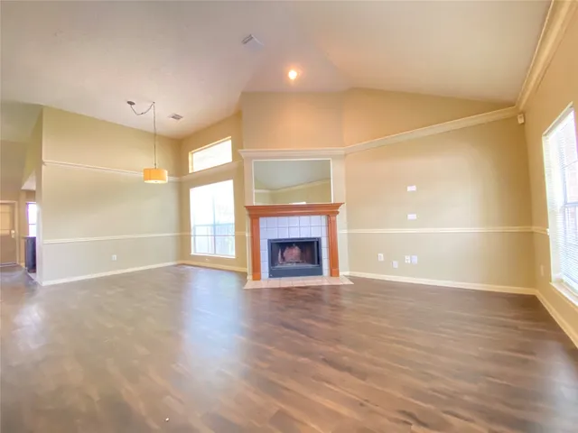 a view of an empty room with a window and fireplace