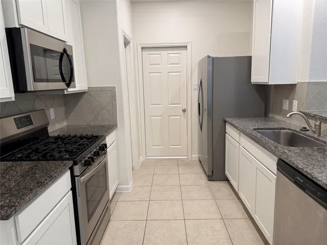 a kitchen with a stove a sink and a refrigerator