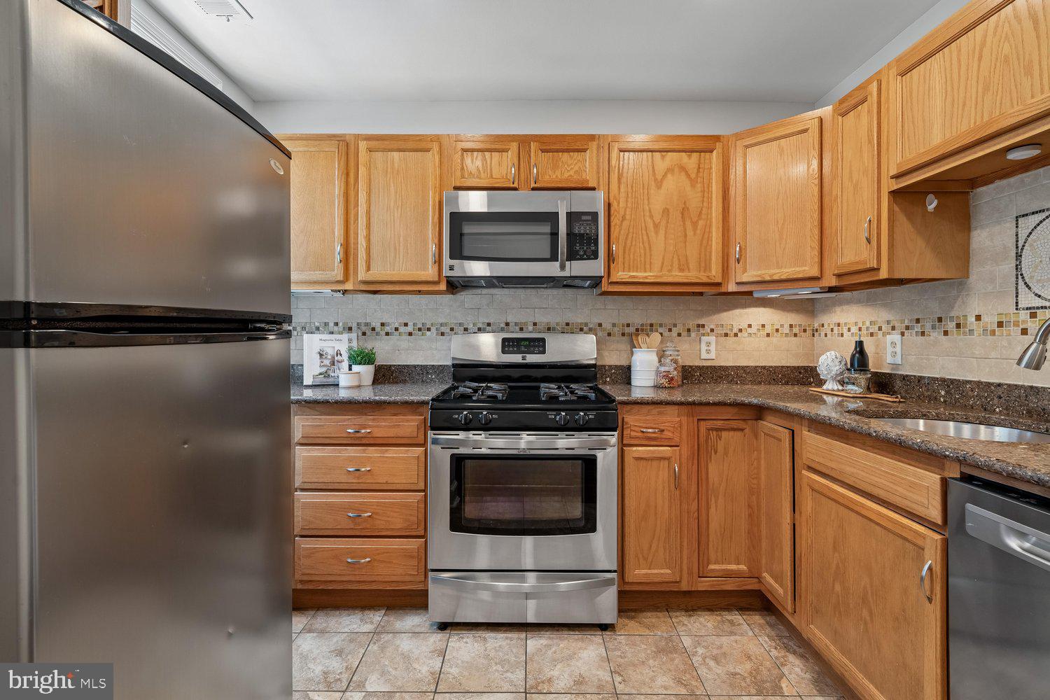 1652 Kramer Street Northeast Washington, DC 20002 - Photo 5 of 26 a kitchen with stainless steel appliances granite countertop a stove a sink and a refrigerator