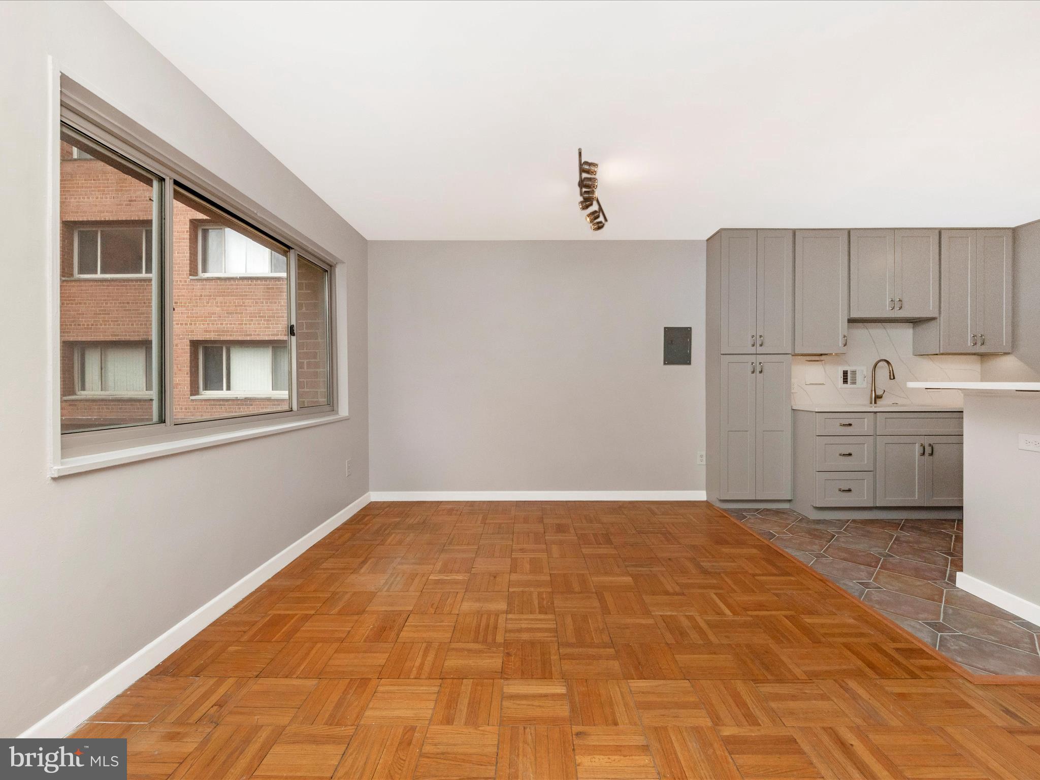 3900 Tunlaw Road Northwest, Unit 104 Washington, DC 20007 - Photo 11 of 36 a view of a kitchen with a sink and cabinet with wooden floor