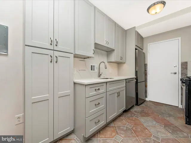 a kitchen with white cabinets and white appliances