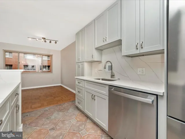 a kitchen with white cabinets and sink