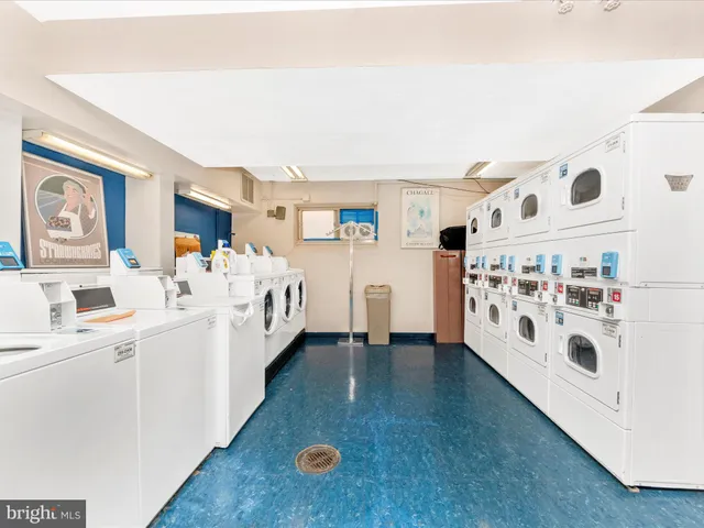 a large white bed sitting in a kitchen next to a window