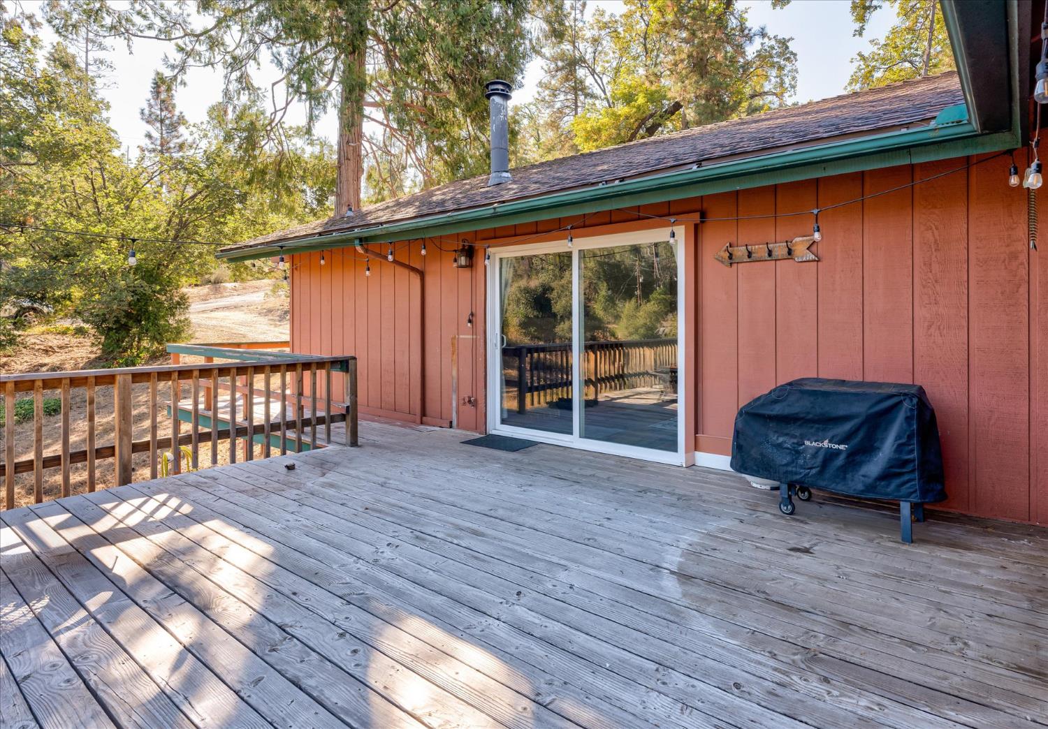 39712 Deer Ridge Drive Oakhurst, CA 93644 - Photo 14 of 40 a backyard of a house with wooden floor and outdoor seating