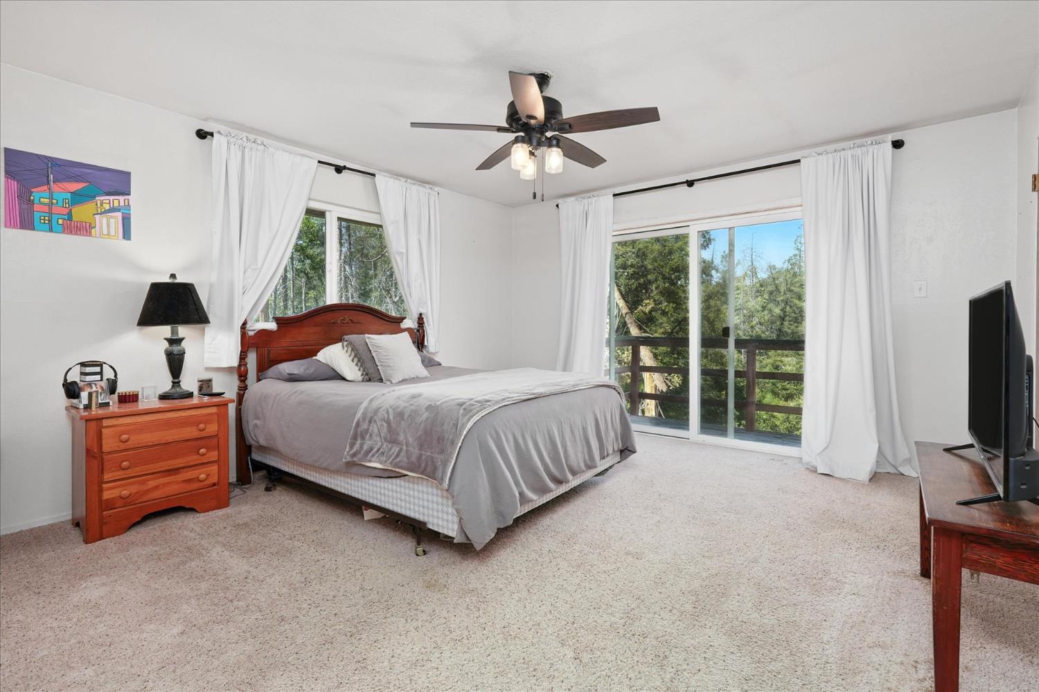 39712 Deer Ridge Drive Oakhurst, CA 93644 - Photo 27 of 40 a bedroom with a bed flat screen tv and a window