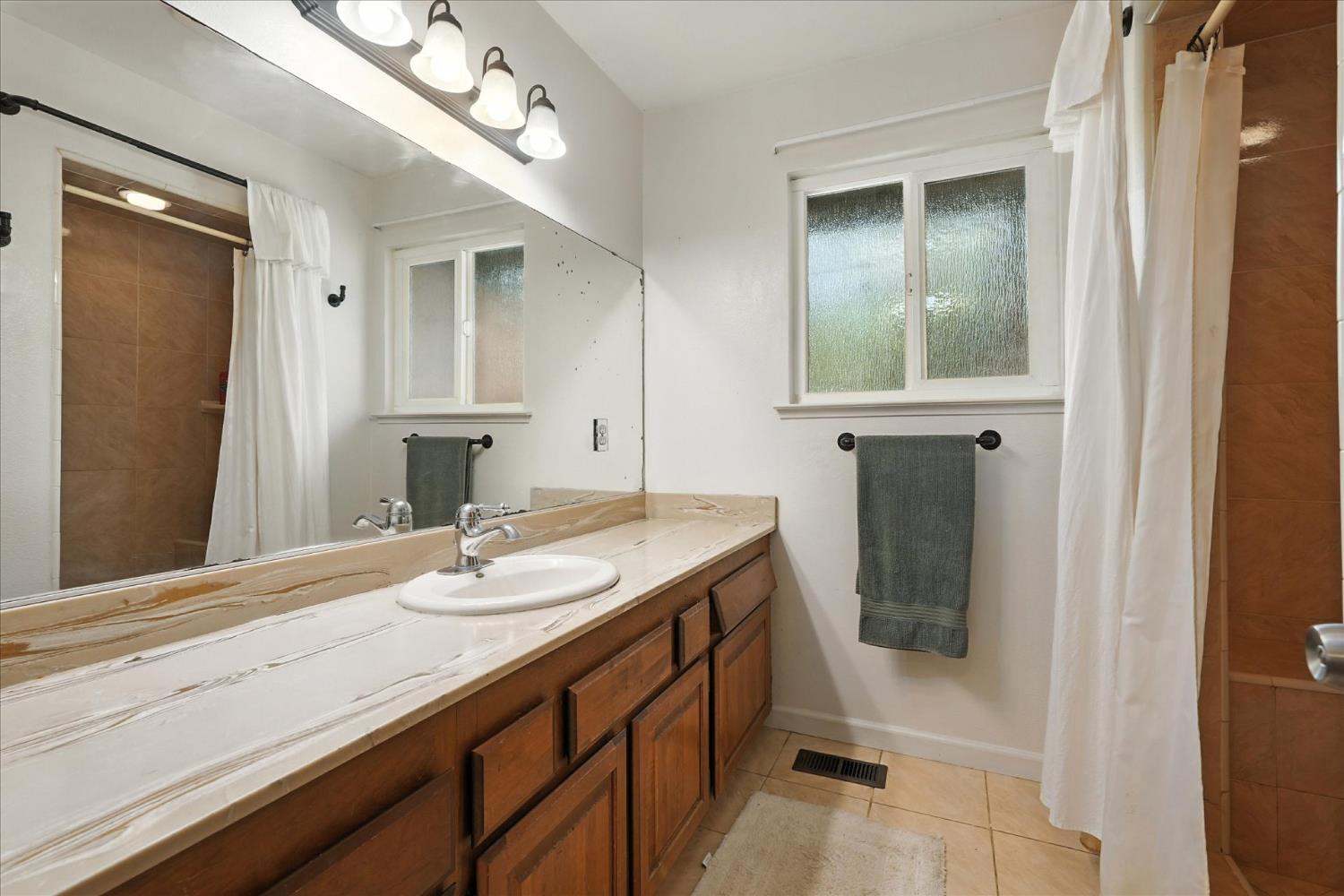 39712 Deer Ridge Drive Oakhurst, CA 93644 - Photo 30 of 40 a bathroom with a granite countertop sink and a mirror