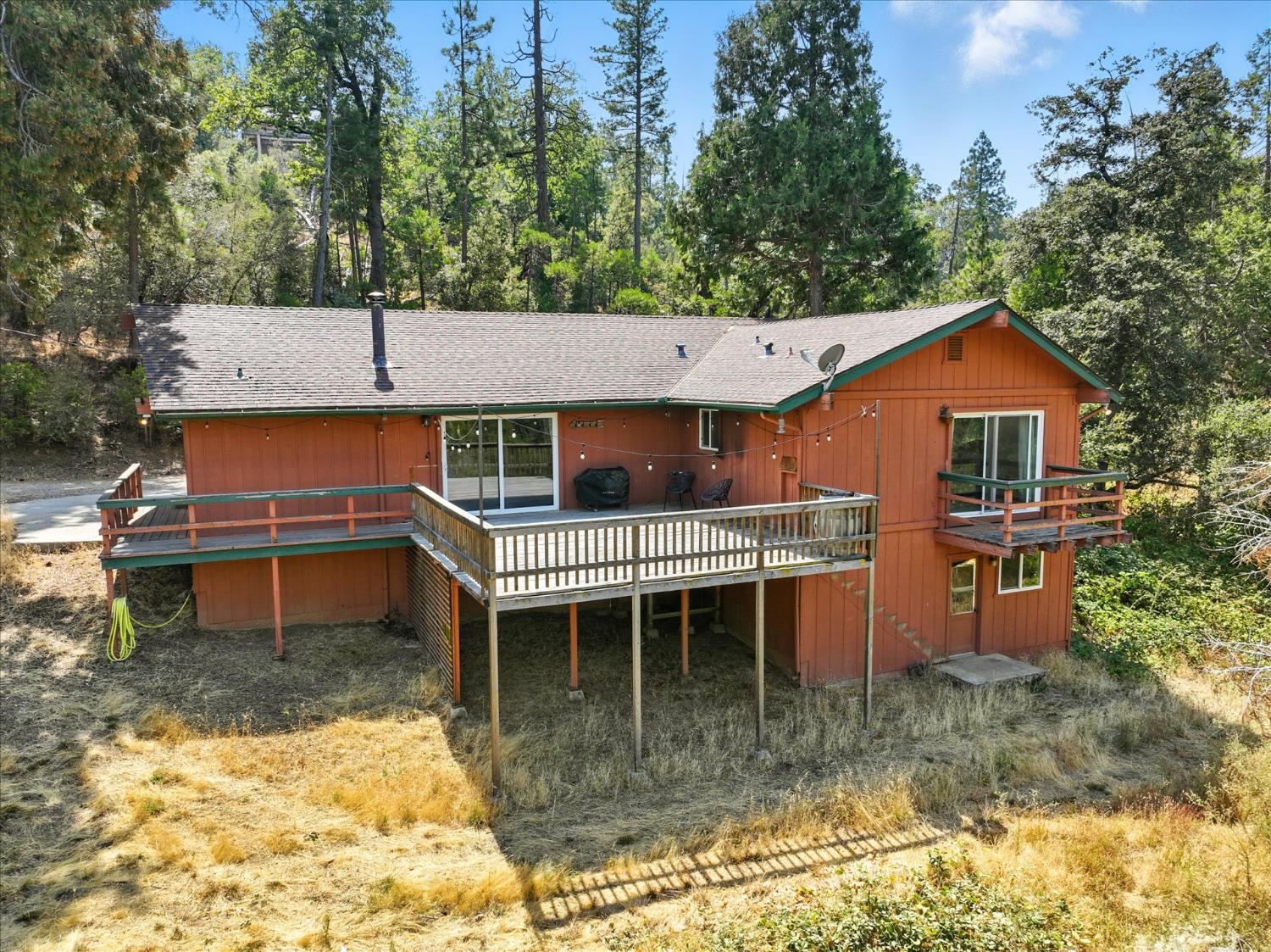 39712 Deer Ridge Drive Oakhurst, CA 93644 - Photo 35 of 40 a front view of a house with a yard patio and fire pit