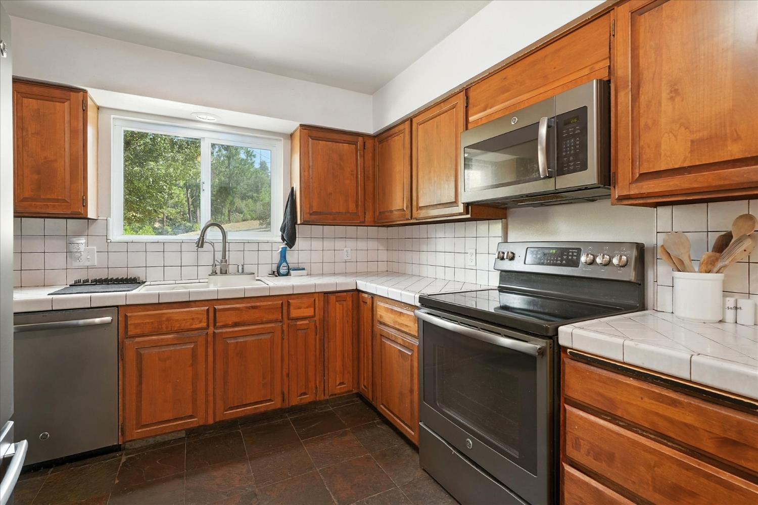 39712 Deer Ridge Drive Oakhurst, CA 93644 - Photo 8 of 40 a kitchen with stainless steel appliances granite countertop a sink stove and microwave