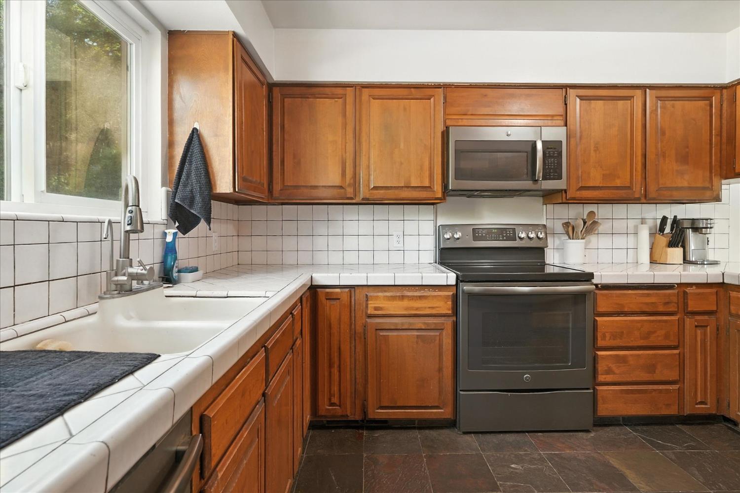 39712 Deer Ridge Drive Oakhurst, CA 93644 - Photo 9 of 40 a kitchen with stainless steel appliances granite countertop a sink stove and microwave